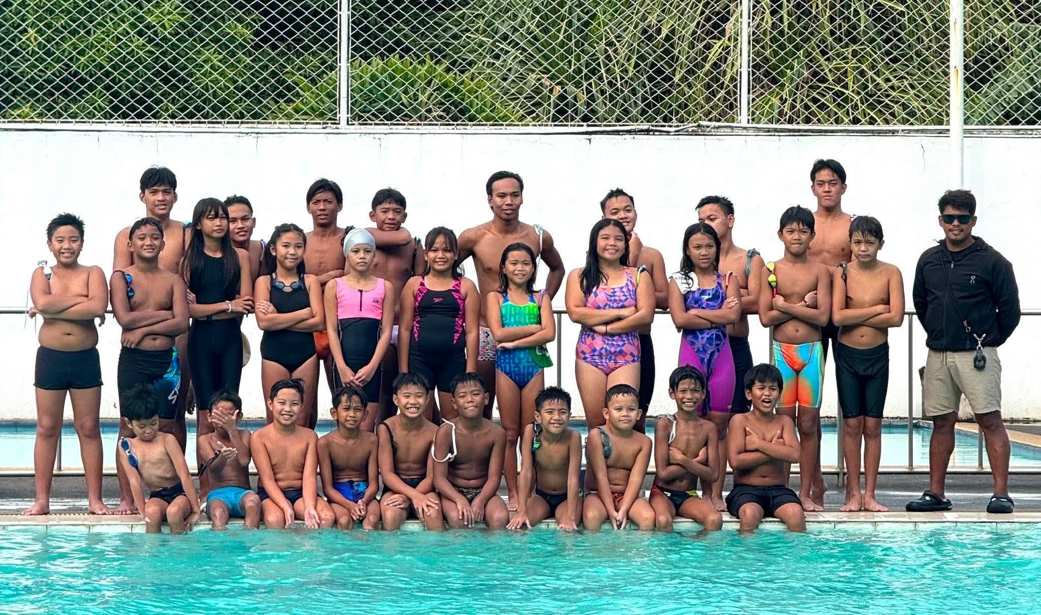 Laguna Barracudas swimmers and coach at the poolside